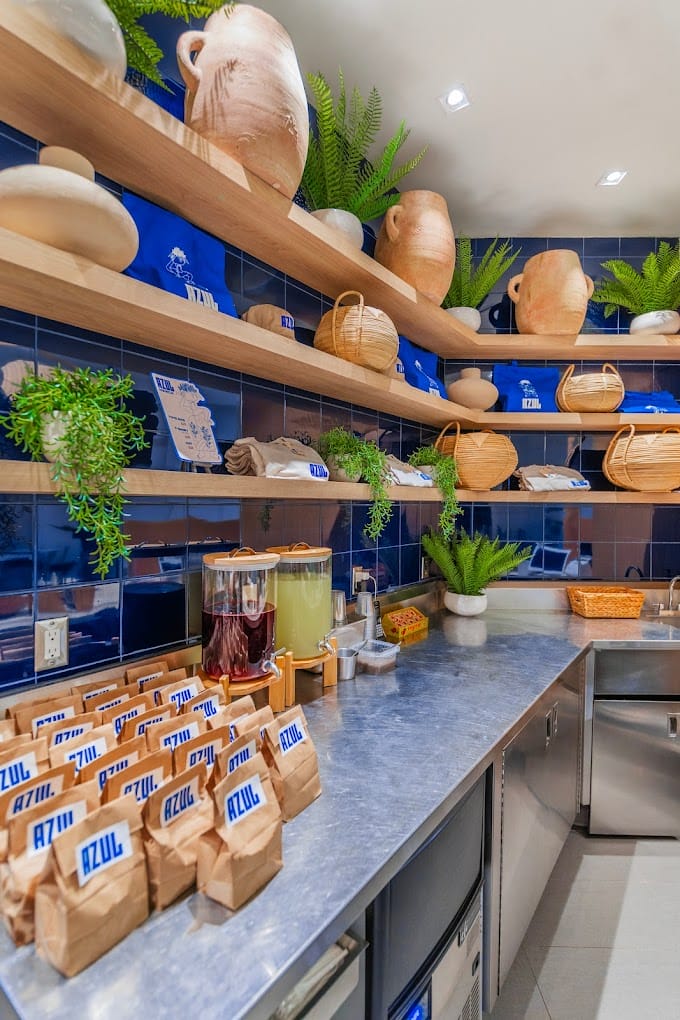Azul counter with cobalt tile, floating oak shelving, terracotta vessels and a stainless service counter.