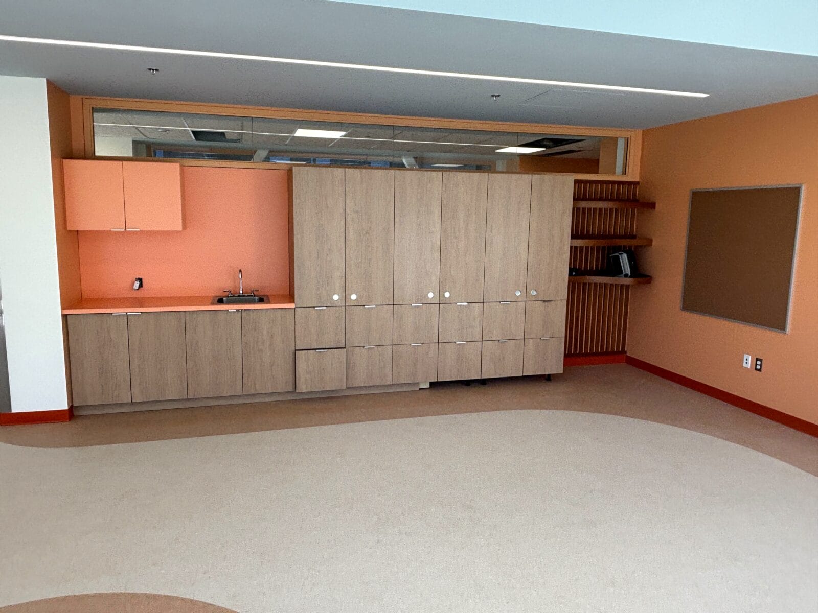 Peach kitchenette with solid-surface counter and slat feature wall