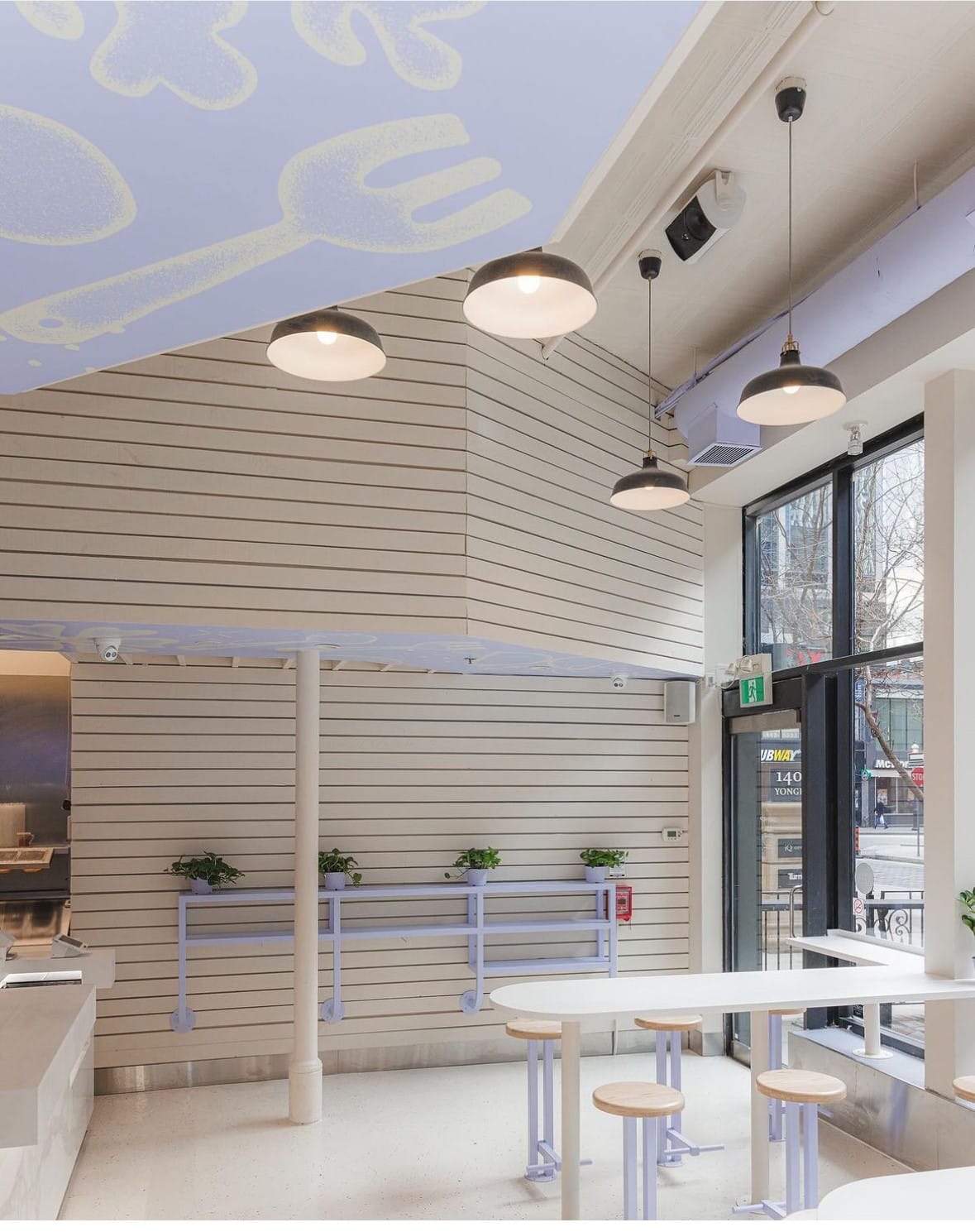 Chop Hop dining area with slat-clad walls and pendant lights