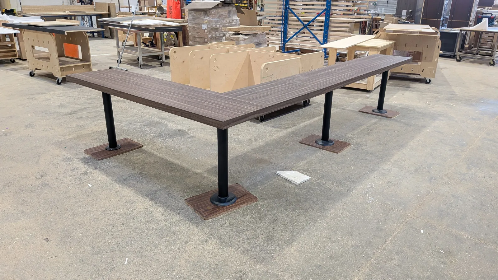 L-shaped laminate bar top on black steel pedestals in the DNS production hall, Vaughan