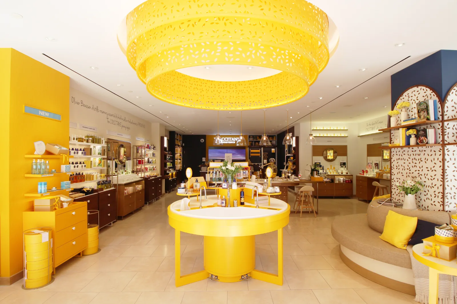 Finished flagship interior with sink island and perimeter wall casework at L'Occitane Bloor Street, Toronto