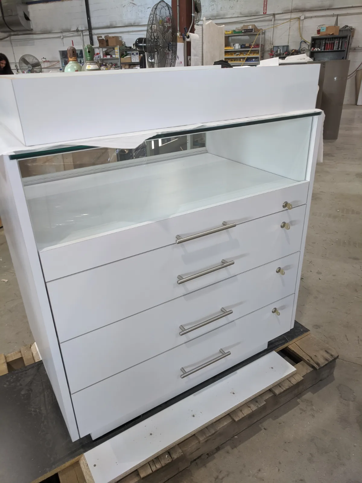 White locking drawer showcase with glass top and brushed pulls, ready for crating at DNS