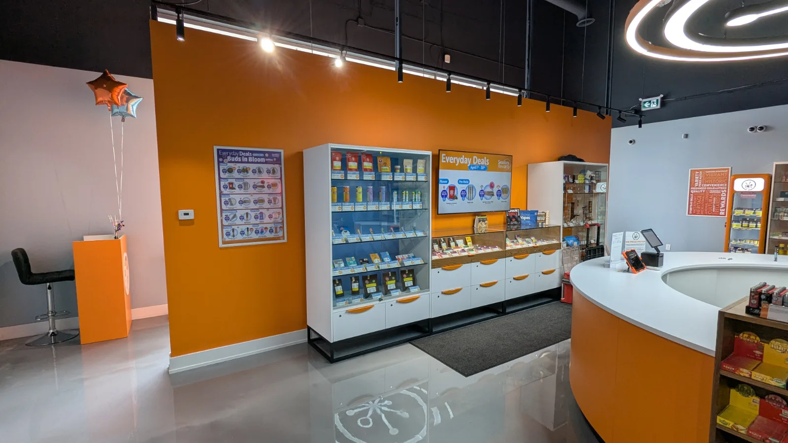 Glass merchandising towers and wall counters with curved cash desk at Sessions Cannabis Cobourg