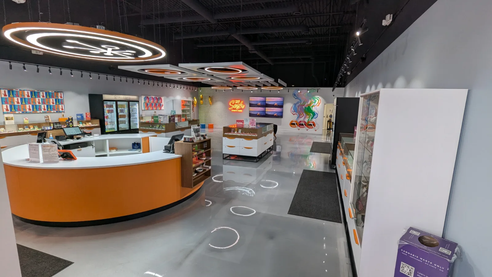 Full store view with curved cash counter, glass showcases and wall cases at Sessions Cannabis Cobourg