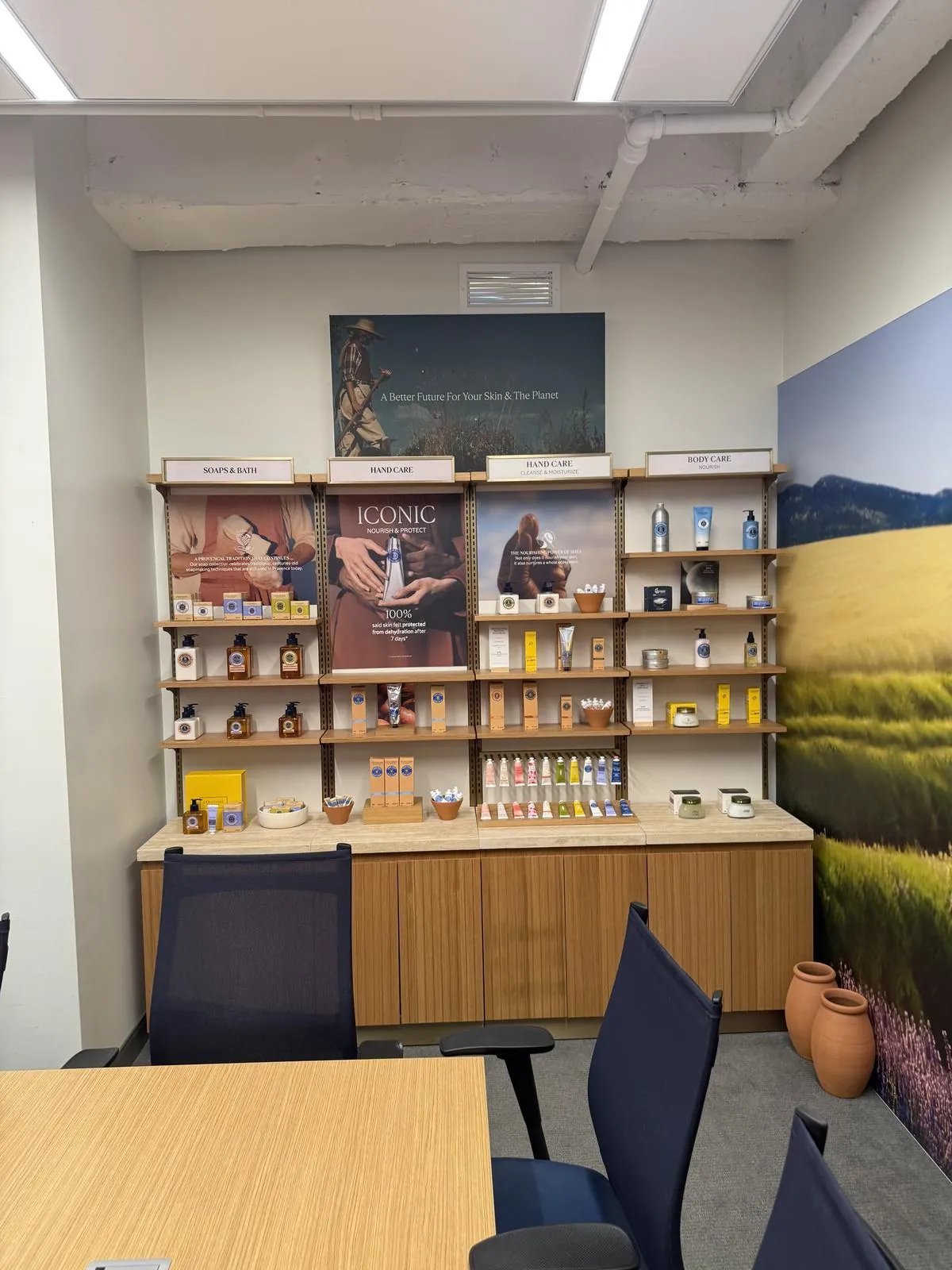 Slotted wall standards and shelving over a base cabinet, with a wall-mounted graphic panel, in a corporate showroom