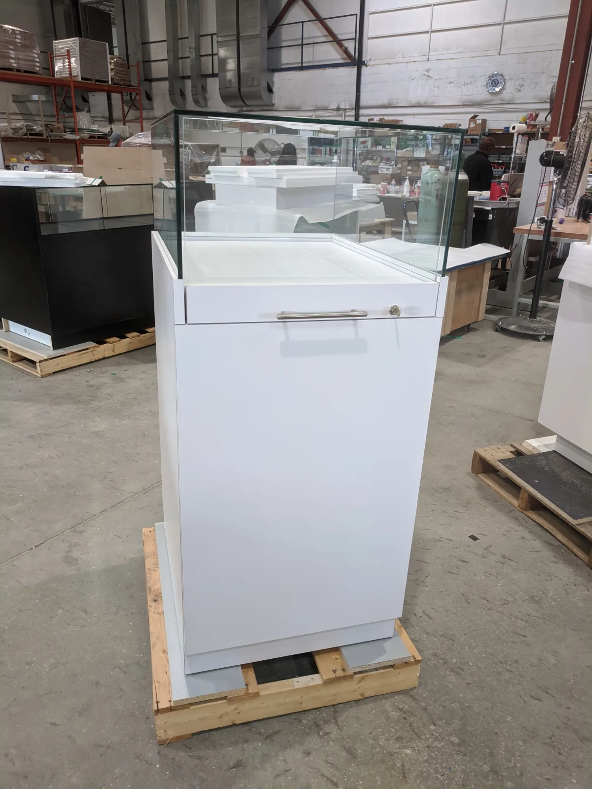 White pedestal showcase with glass vitrine in the DNS shop before shipping