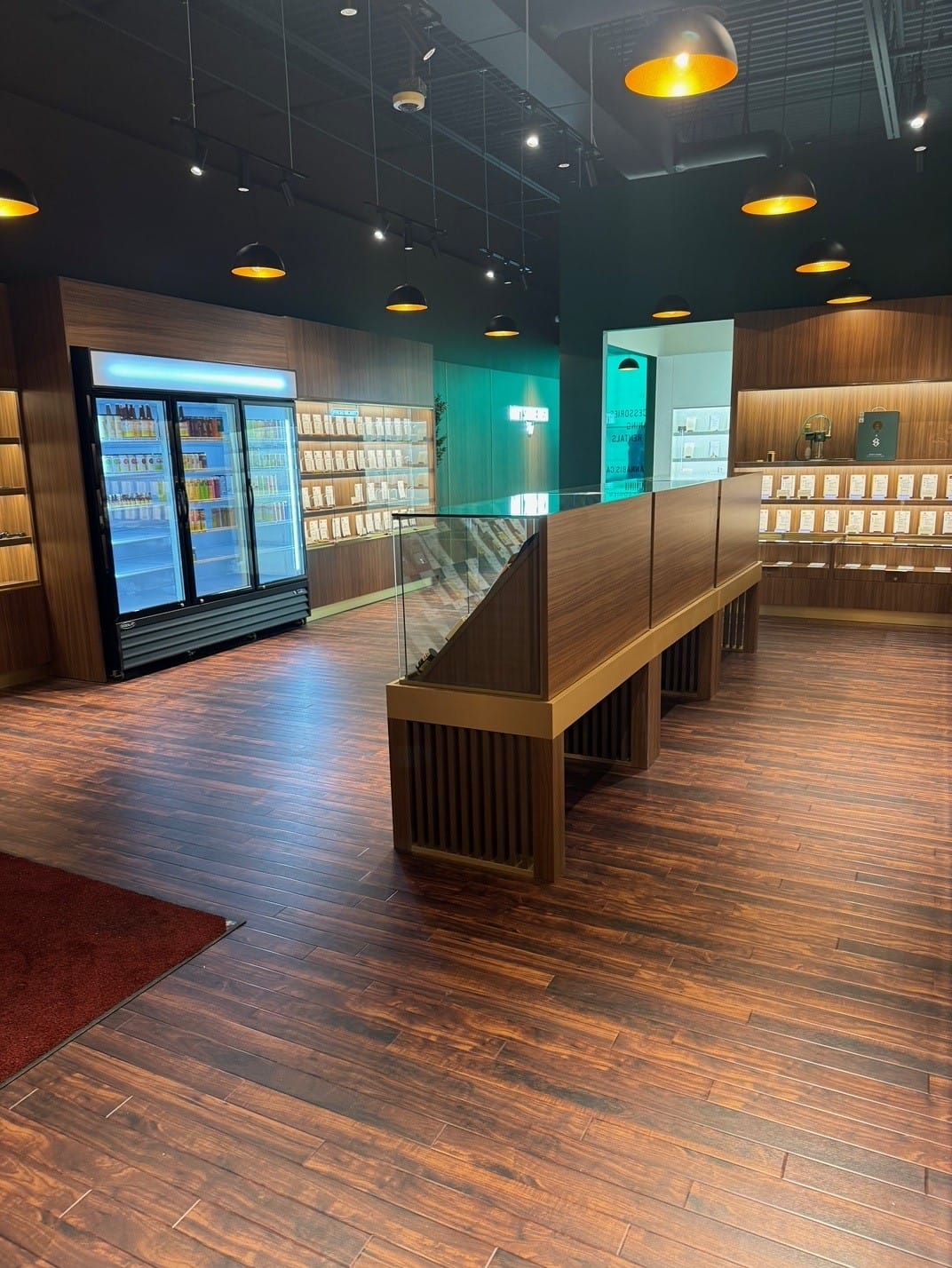 View down the Woods Cannabis store past the display tables to the back wall
