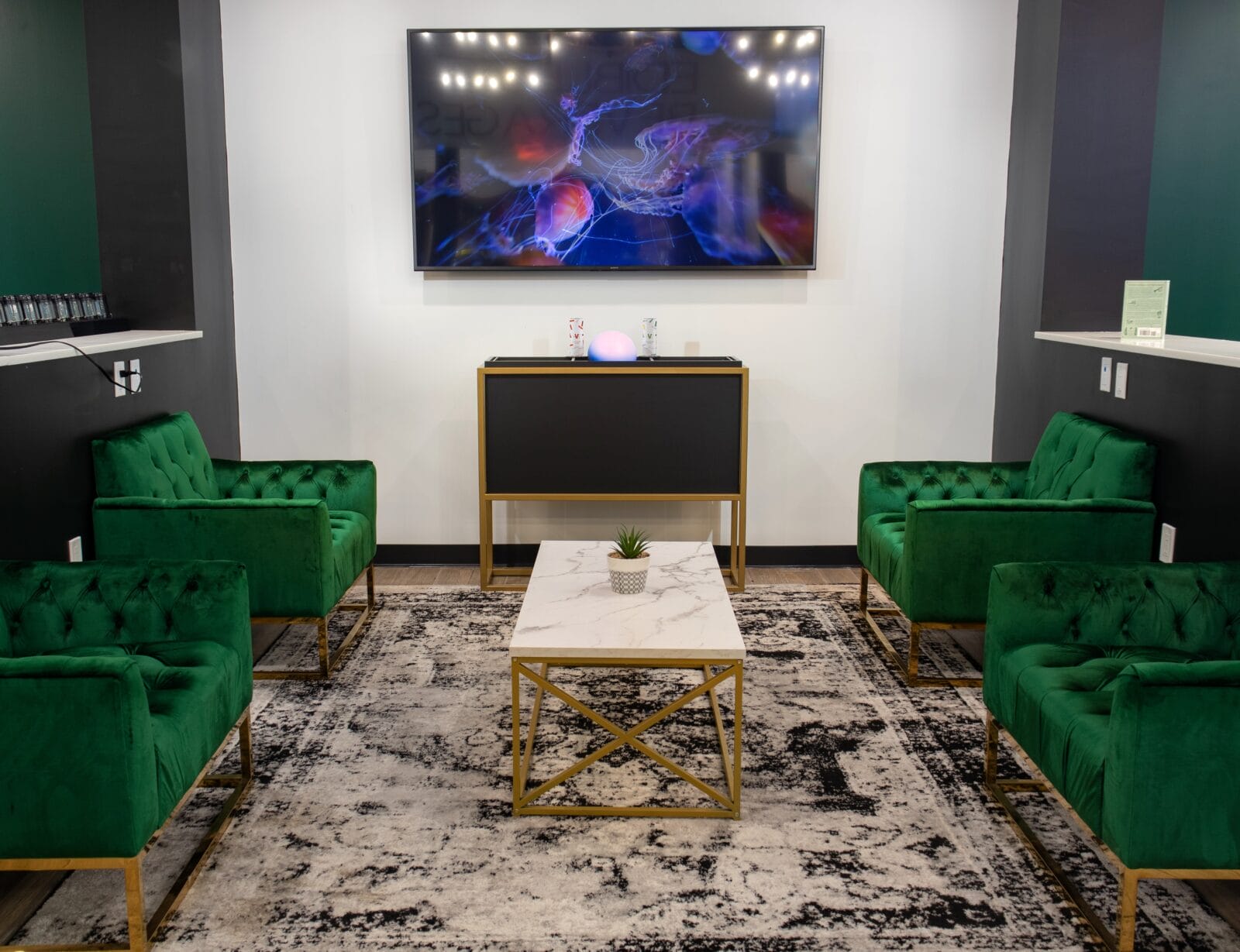 Modern lounge with green velvet chairs and TV