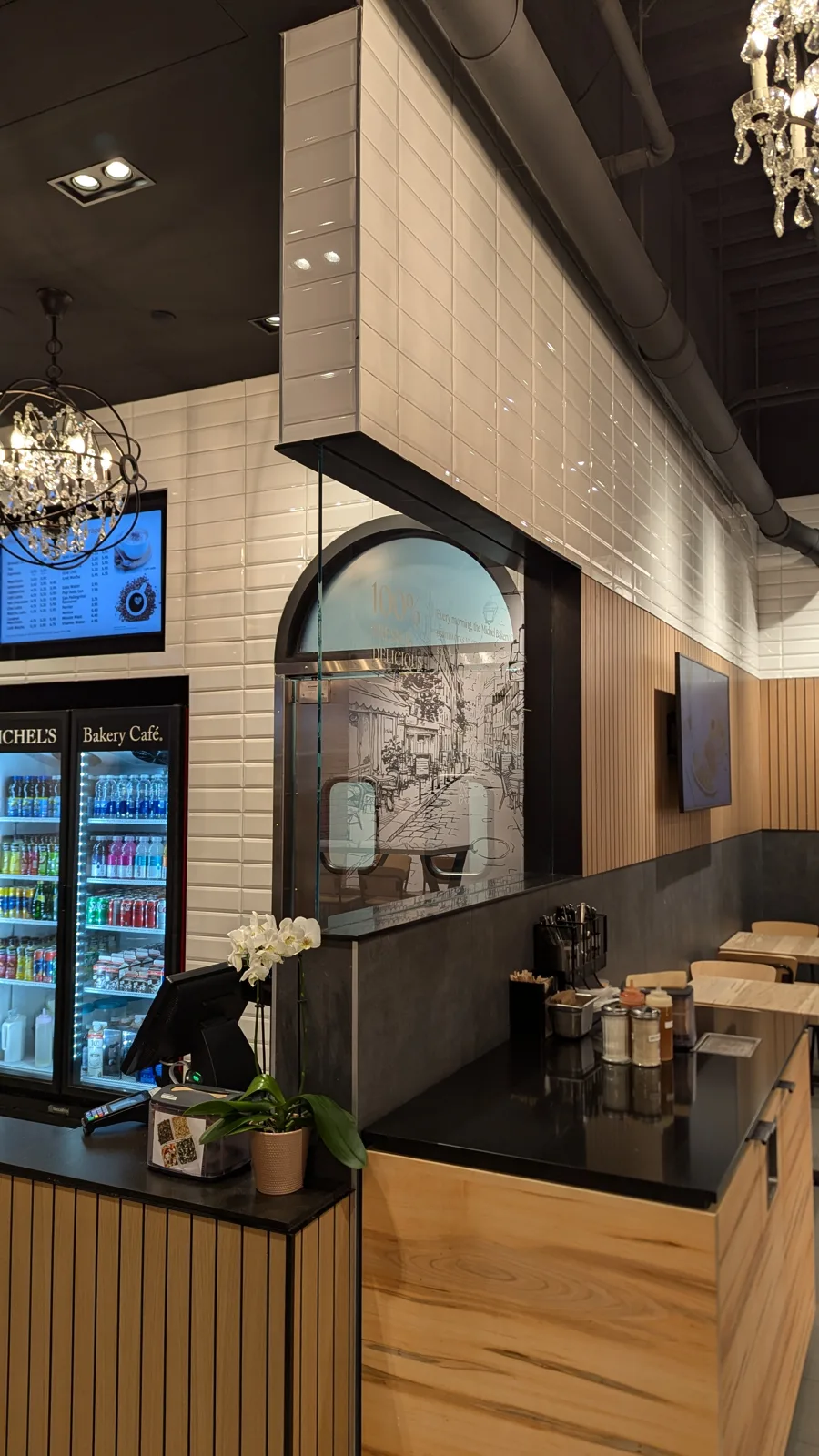 Michel's Bakery Café counter at Yorkdale with a slatted counter front, black top and a maple-veneer condiment station