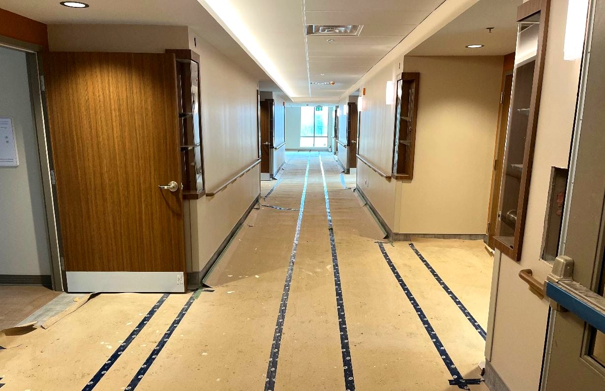 Hospital hallway under renovation with stripped flooring